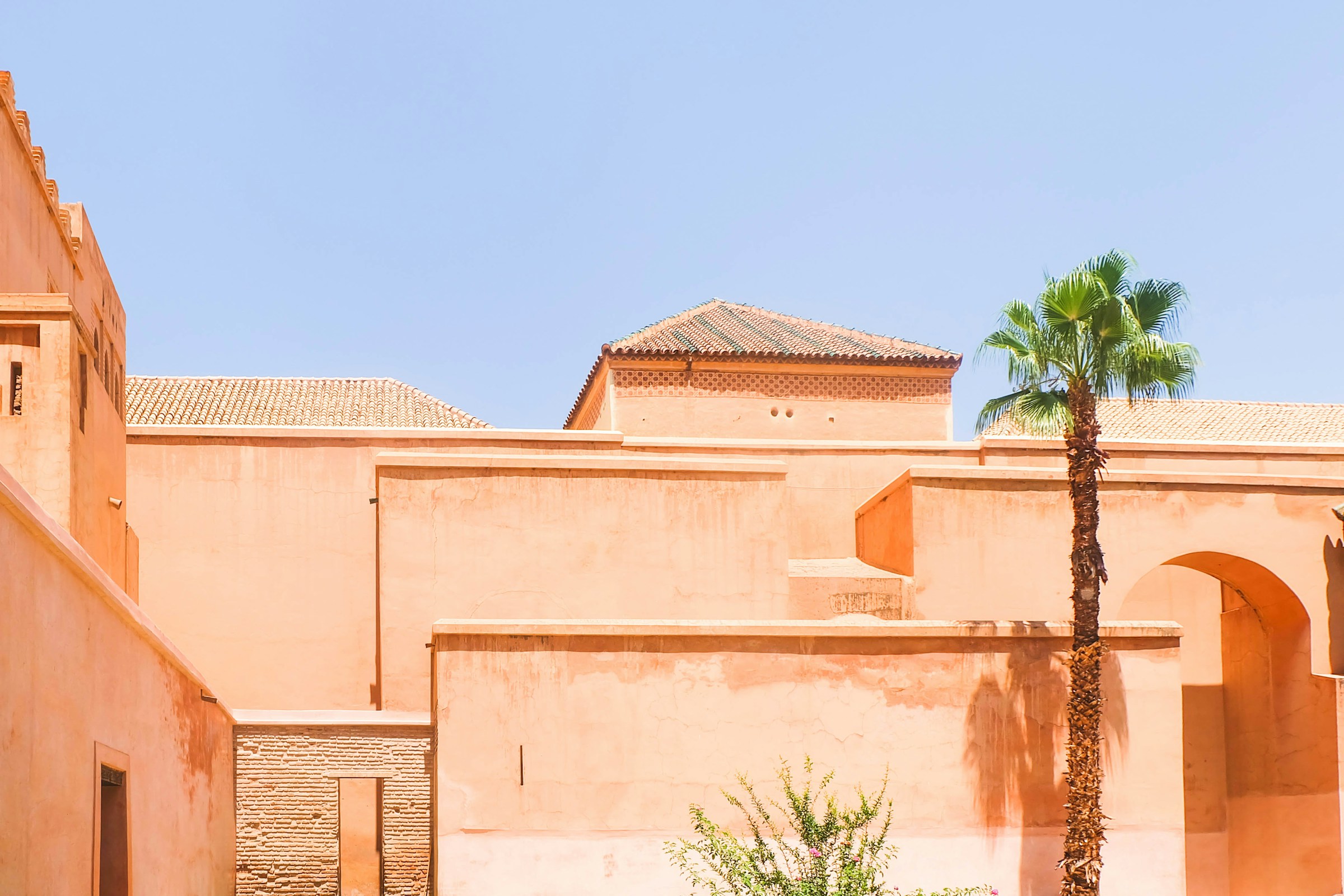 Sun-drenched Marrakech rooftops and palm trees under a bright blue summer sky