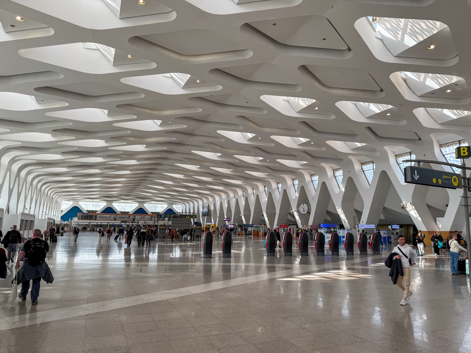 A traveller checking their phone in the arrivals hall at Marrakech Menara airport