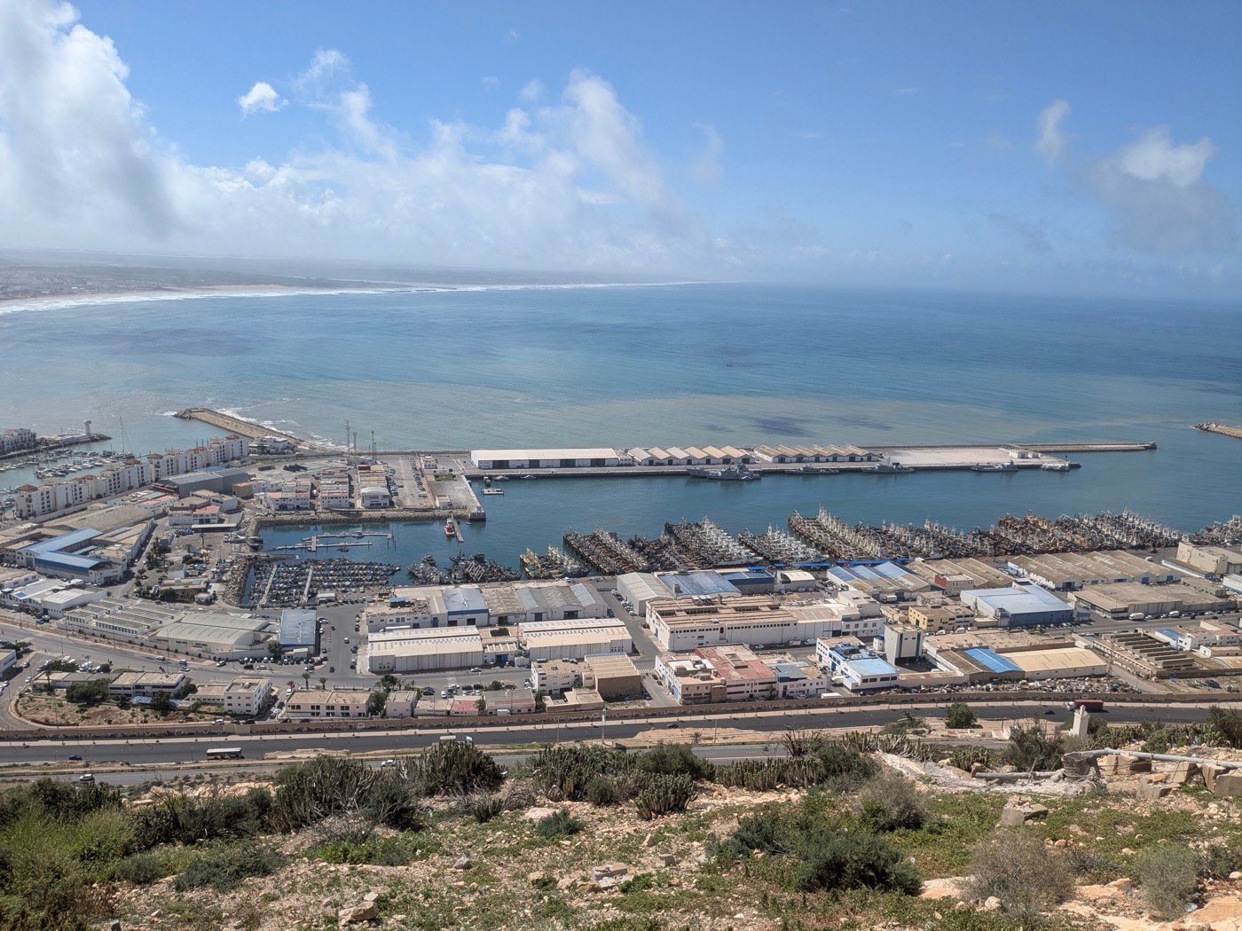 Café terraces and white apartment blocks around the moored boats at Agadir Marina