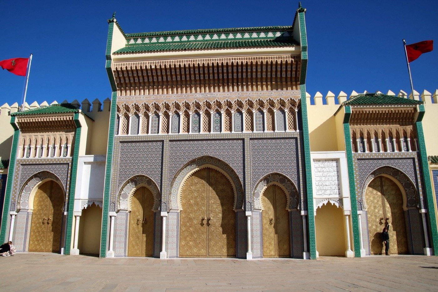 Red petit taxi waiting outside a gate of the Fes medina