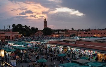 Evening crowds and food stalls filling Jemaa el-Fna square in Marrakech at dusk