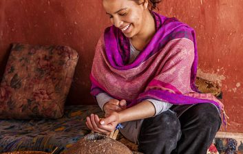 Female traveller buying spices in a Moroccan souk wearing loose modest clothing